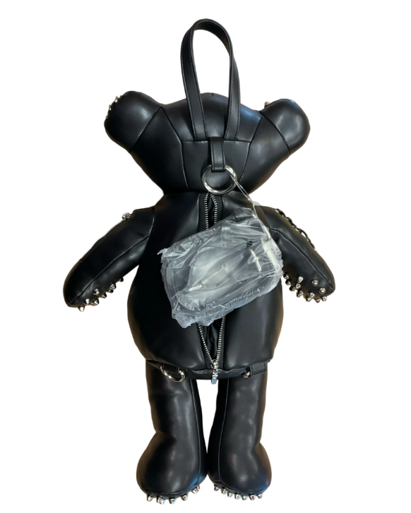 A black faux-leather teddy bear backpack styled with silver studs, zippers, and metal hardware, shown against a plain white background.
