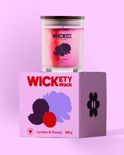 Wickety Wack candle and packaging on a pink background