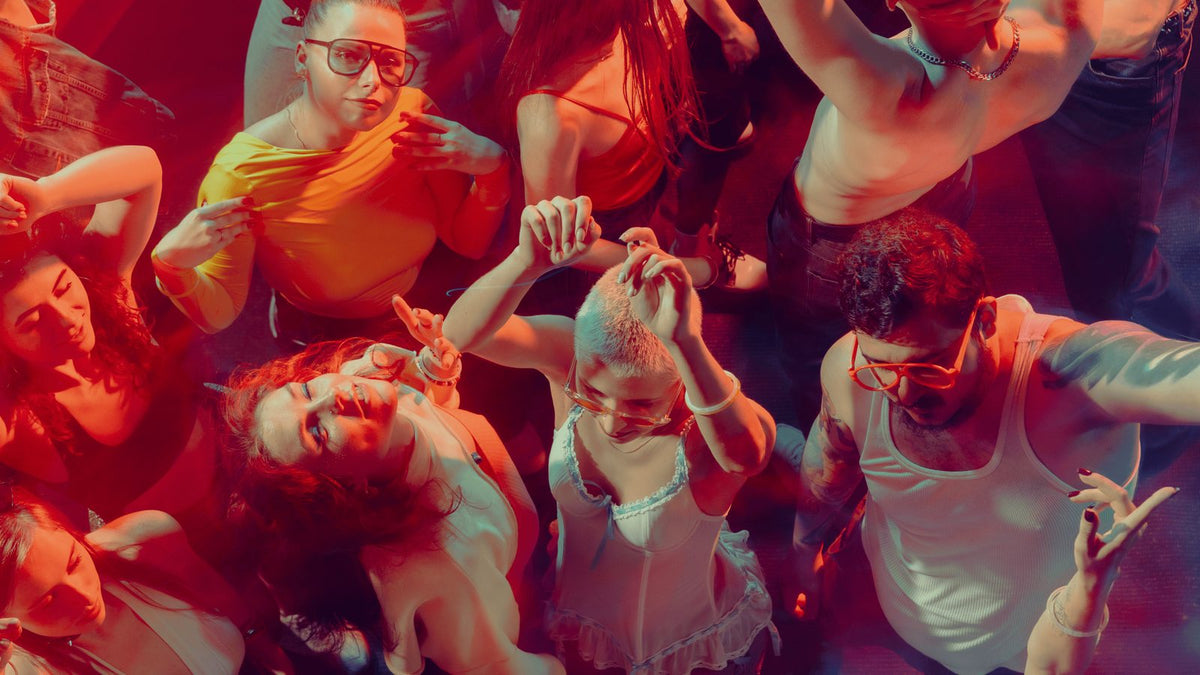 A crowd dancing at a party under red lights