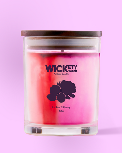 Candle with 'Wickety Wick' branding on a pink background