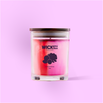 Candle with 'Wickety Wick' branding on a pink background