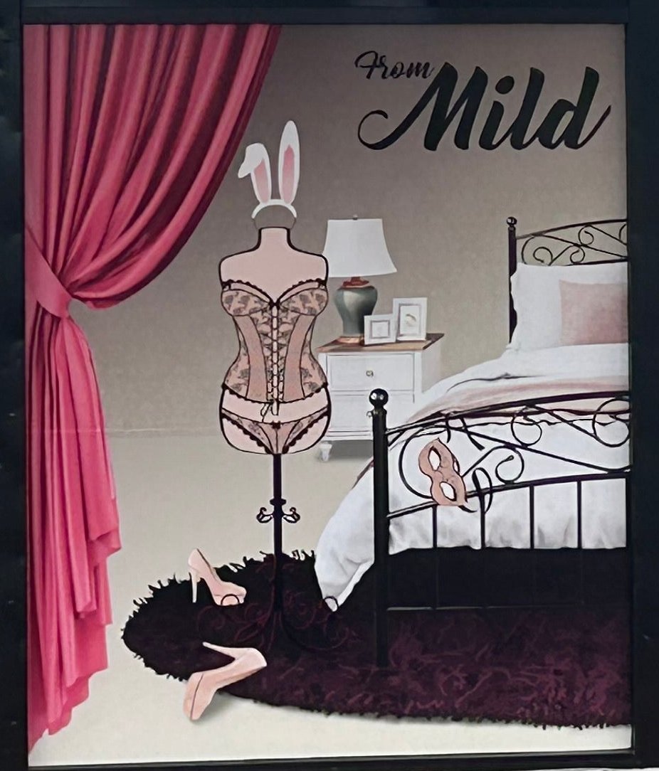Window display at The Diva's Den, Mackay: a lingerie mannequin beside a bed